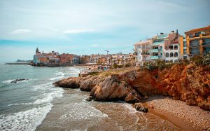 Sitges coastline with rocky coves and beachfront buildings near Barcelona, Catalonia