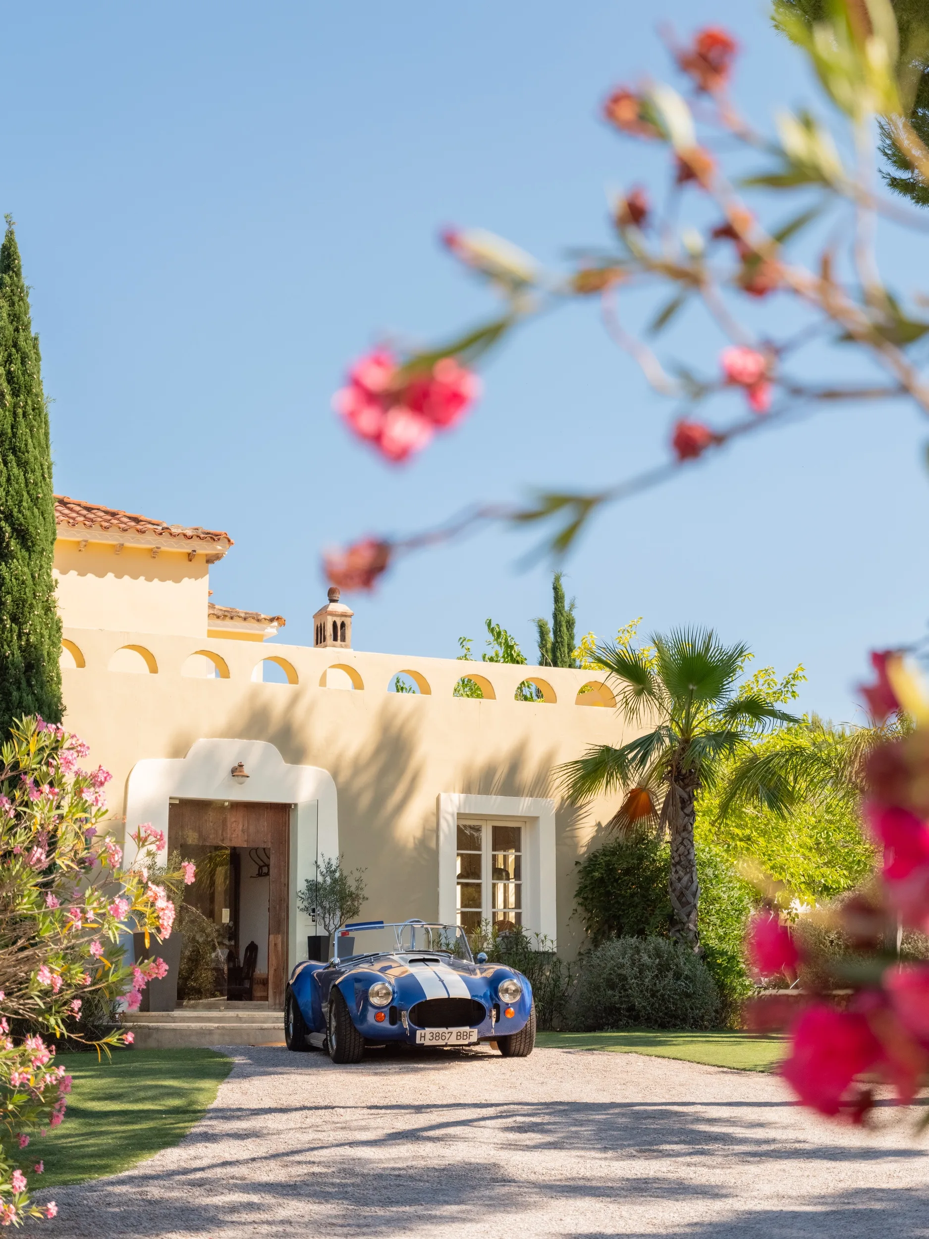 Clásico coche deportivo azul aparcado en la entrada de la Finca Casa Nova