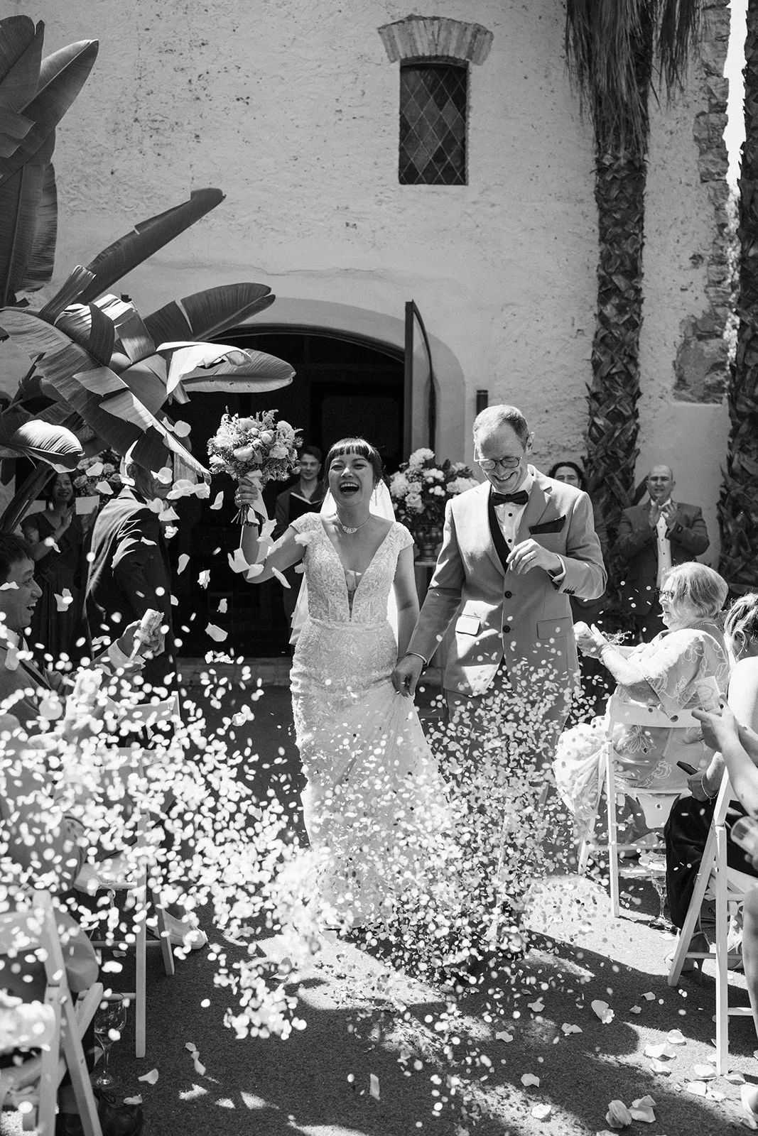 Newlyweds walking through a shower of confetti after the ceremony