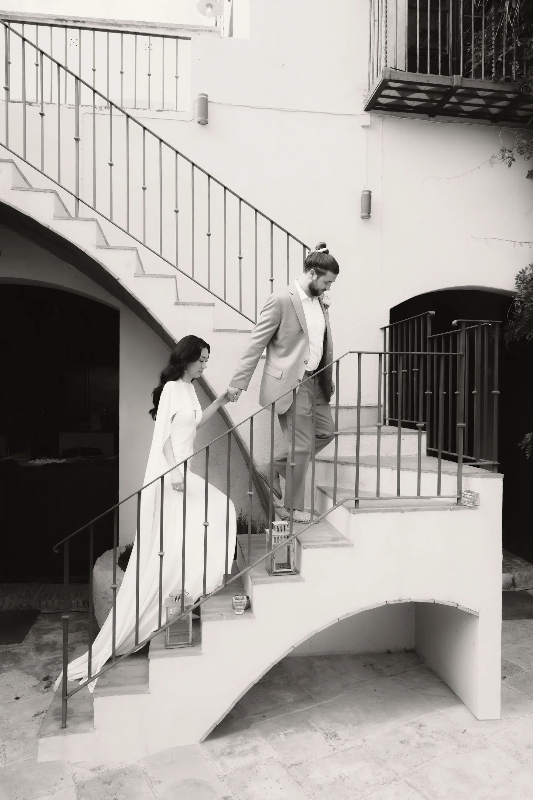 Pareja fotografiada en la escalera exterior encalada de la villa