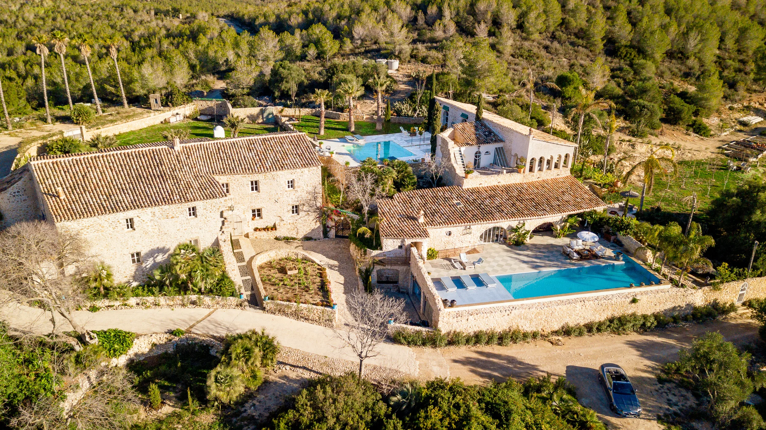 Vista aérea de la Villa Alcázar del Garraf que muestra sus dos piscinas y tejados de terracota