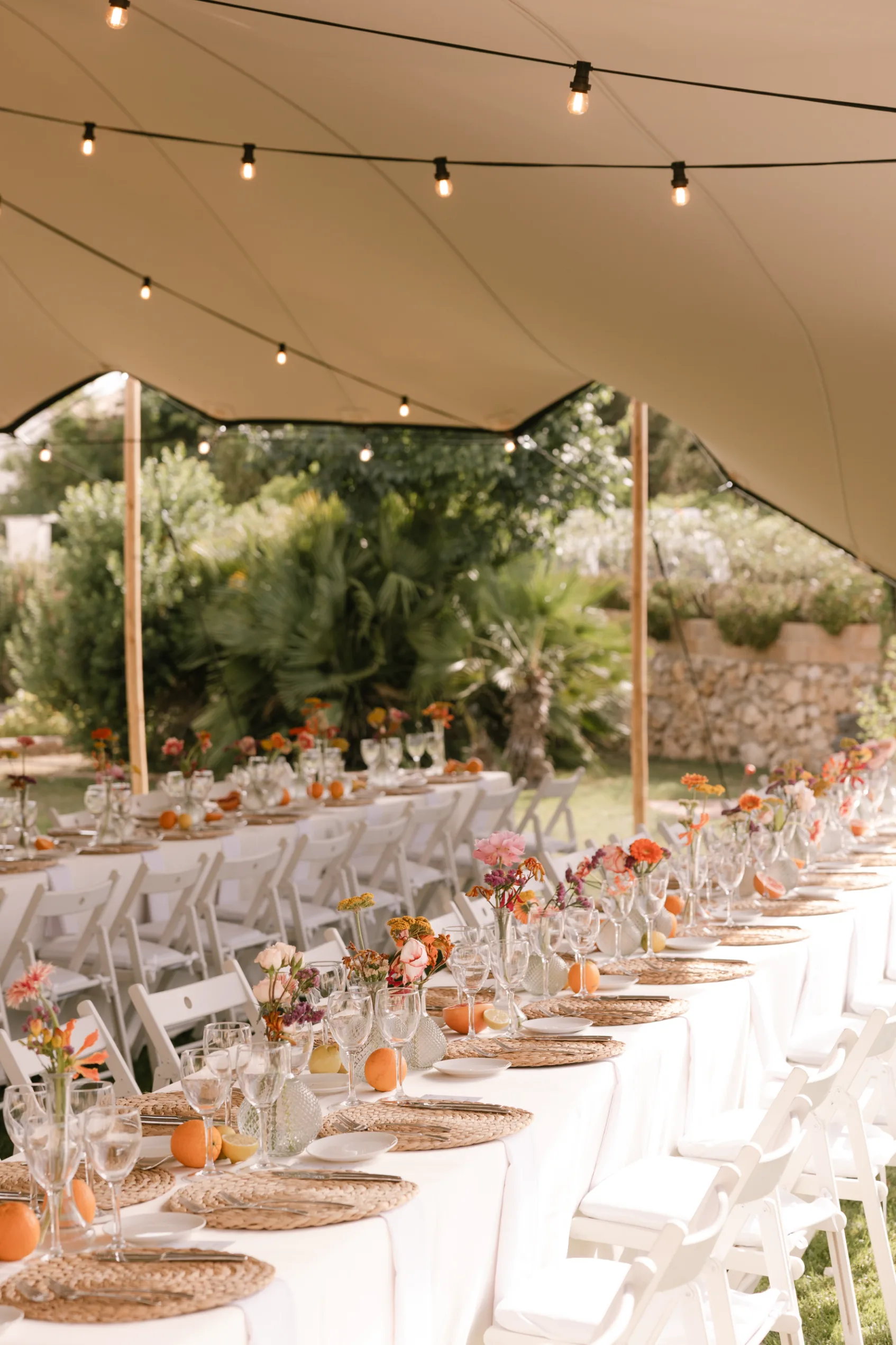 Wedding banquet under a marquee with festoon lights at Villa Alcazar del Garraf