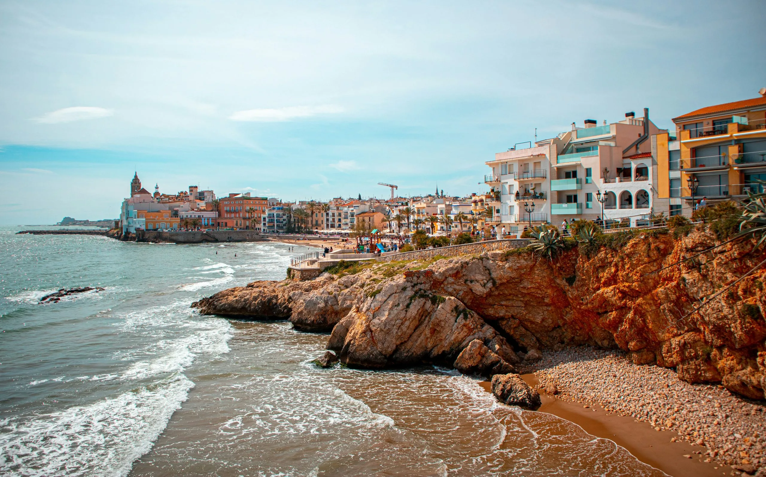 La costa de Sitges amb el nucli antic d'allotjament darrere de les roques