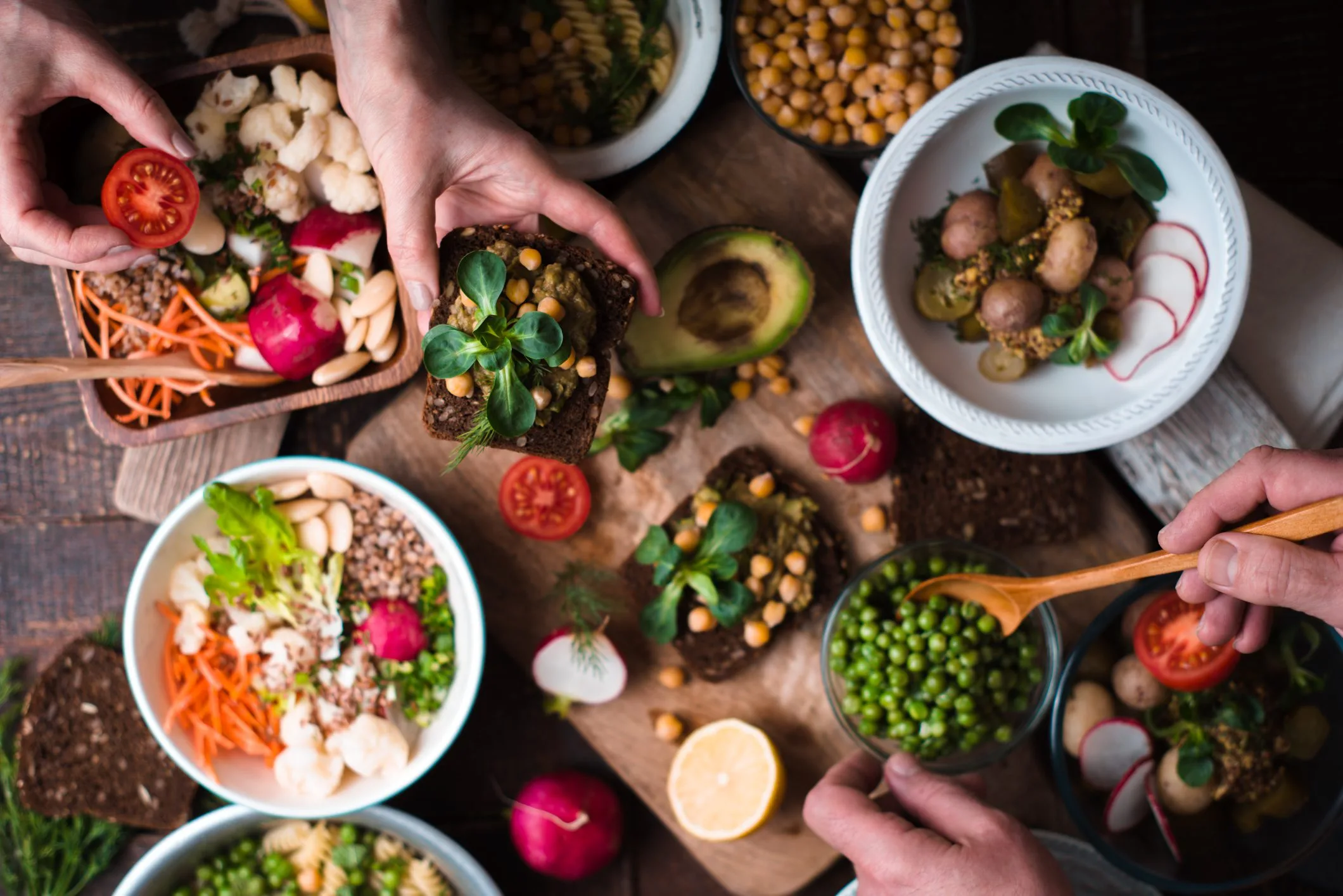 Chef preparing vegan tapas with avocado, chickpeas and fresh vegetables