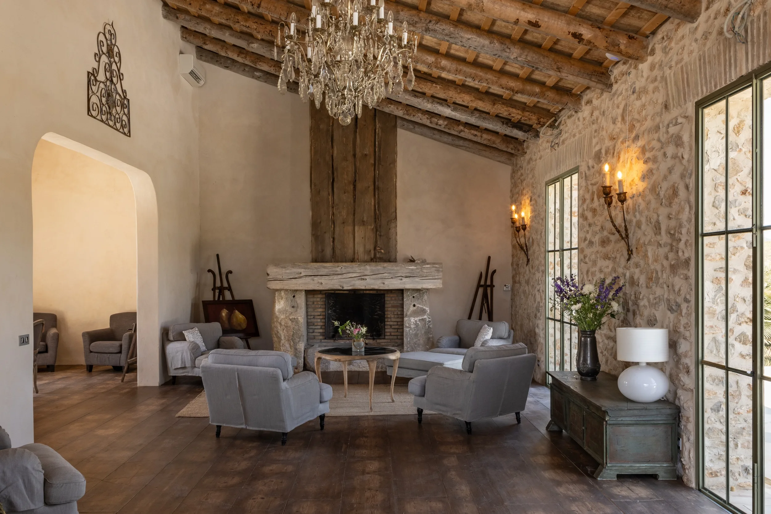 Sala de estar con chimenea de piedra y lámpara de araña en la Mansión Los Naranjos