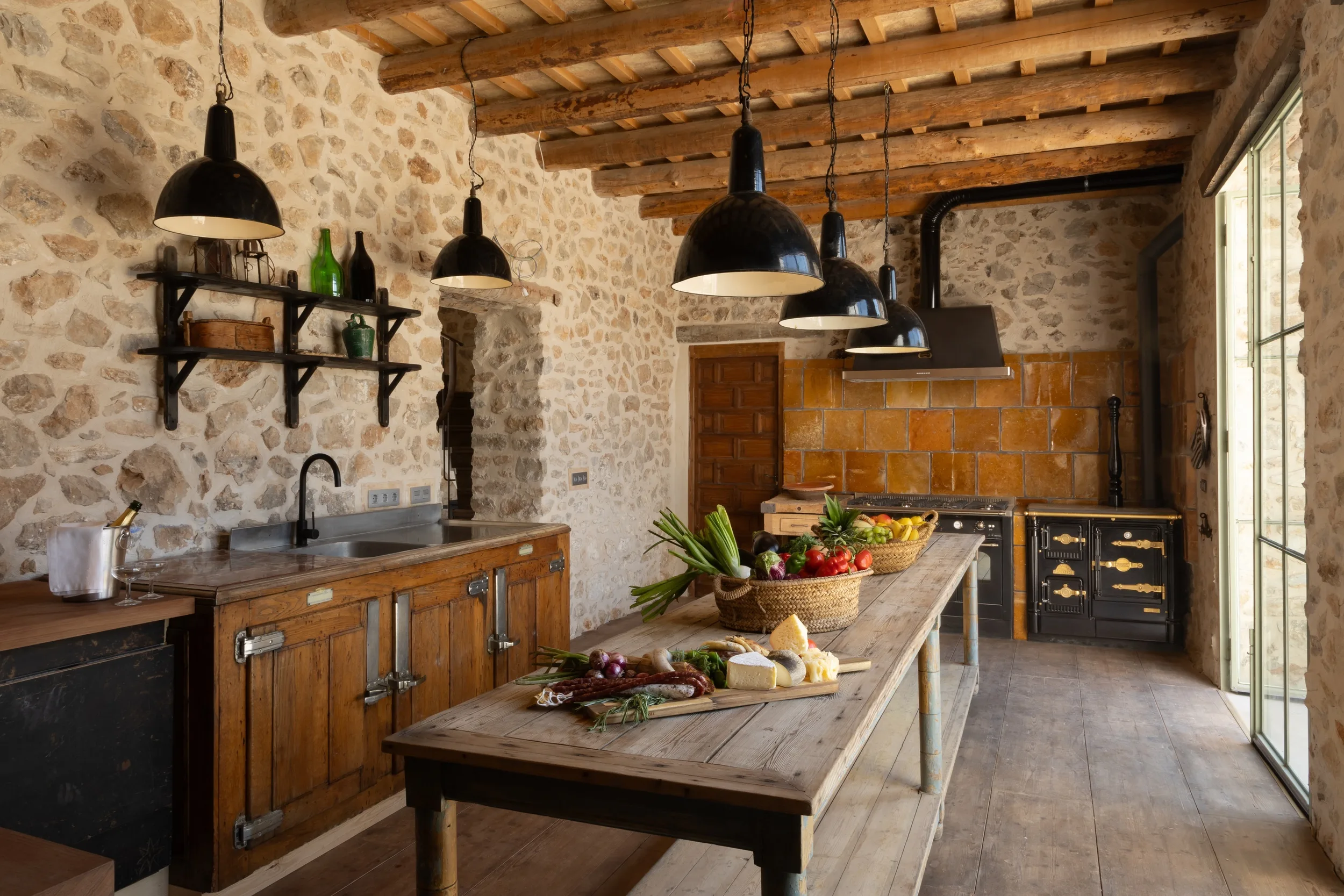 Cocina rústica en Mansión Los Naranjos con luces colgantes y productos frescos sobre la mesa